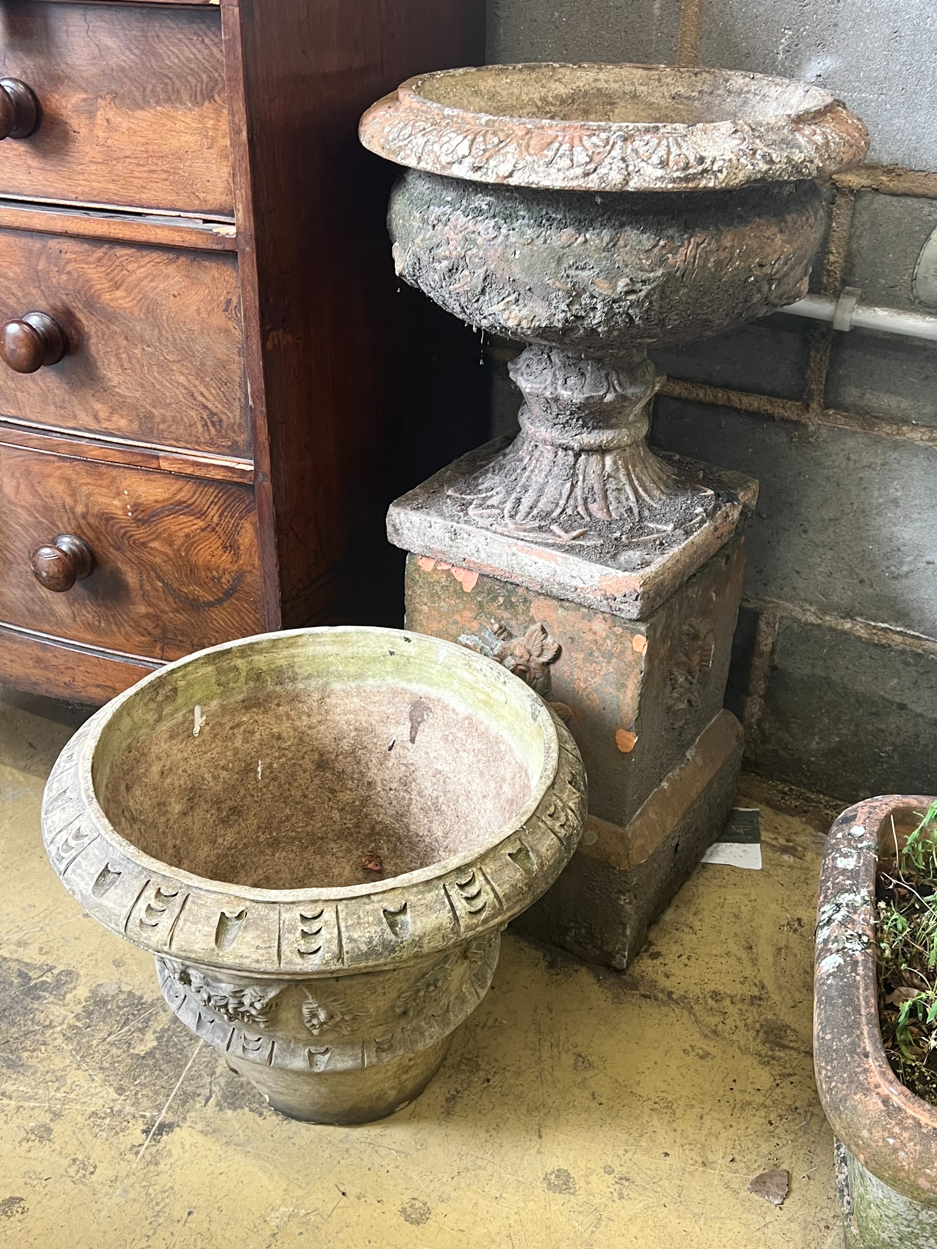 A terracotta campana garden urn on square plinth, height 77cm., together with a circular reconstituted stone garden planter